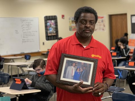 Elise Harris | Golden Eye
Jonesboro High School Coach C.C. Smith holds a portrait of his family in his classroom at JHS.